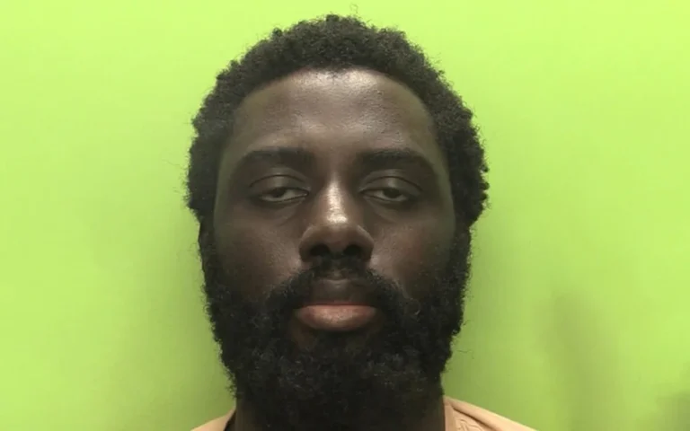 A man in a prison cell, with a judge's gavel and a scale of justice in the background, highlighting the issue of racial bias in the justice system and the premature release of the Nottingham killer
