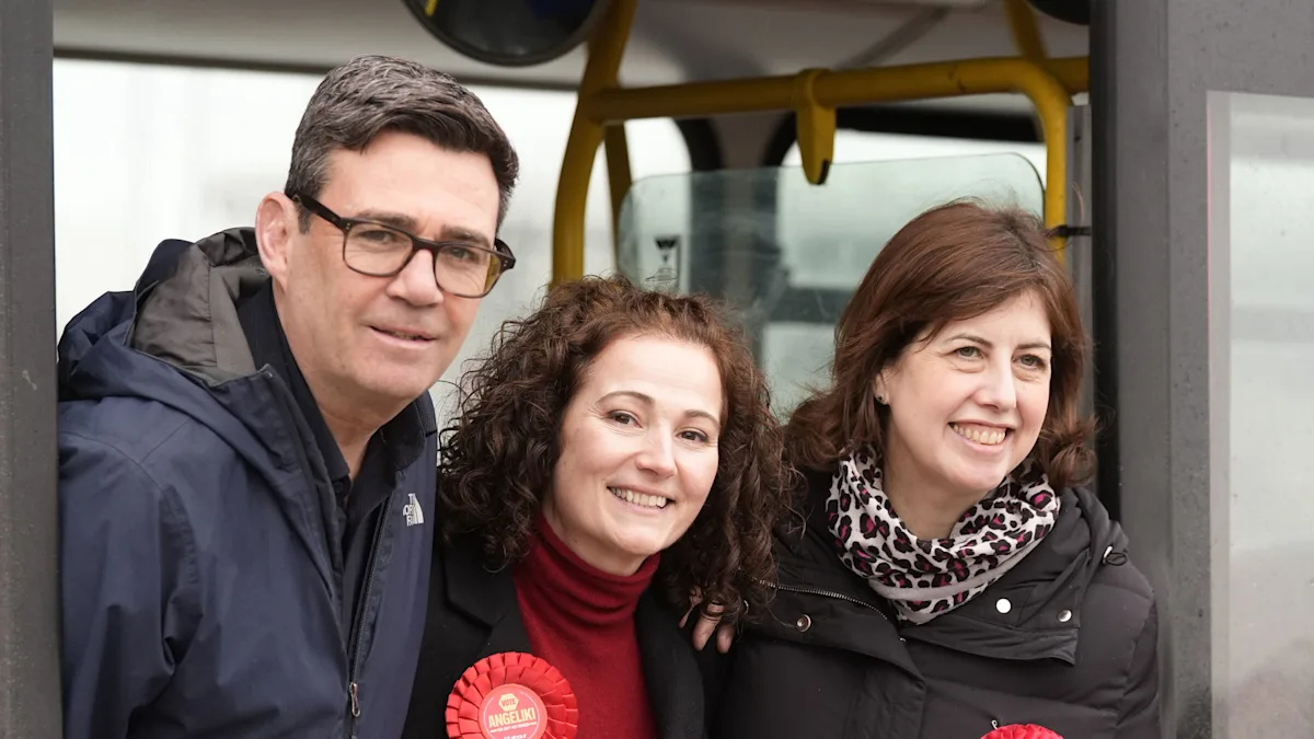 Andy Burnham speaking at a Labour party event, with a confident expression, surrounded by supporters, highlighting his potential by-election victory and influence on Labour's behaviour and political stance