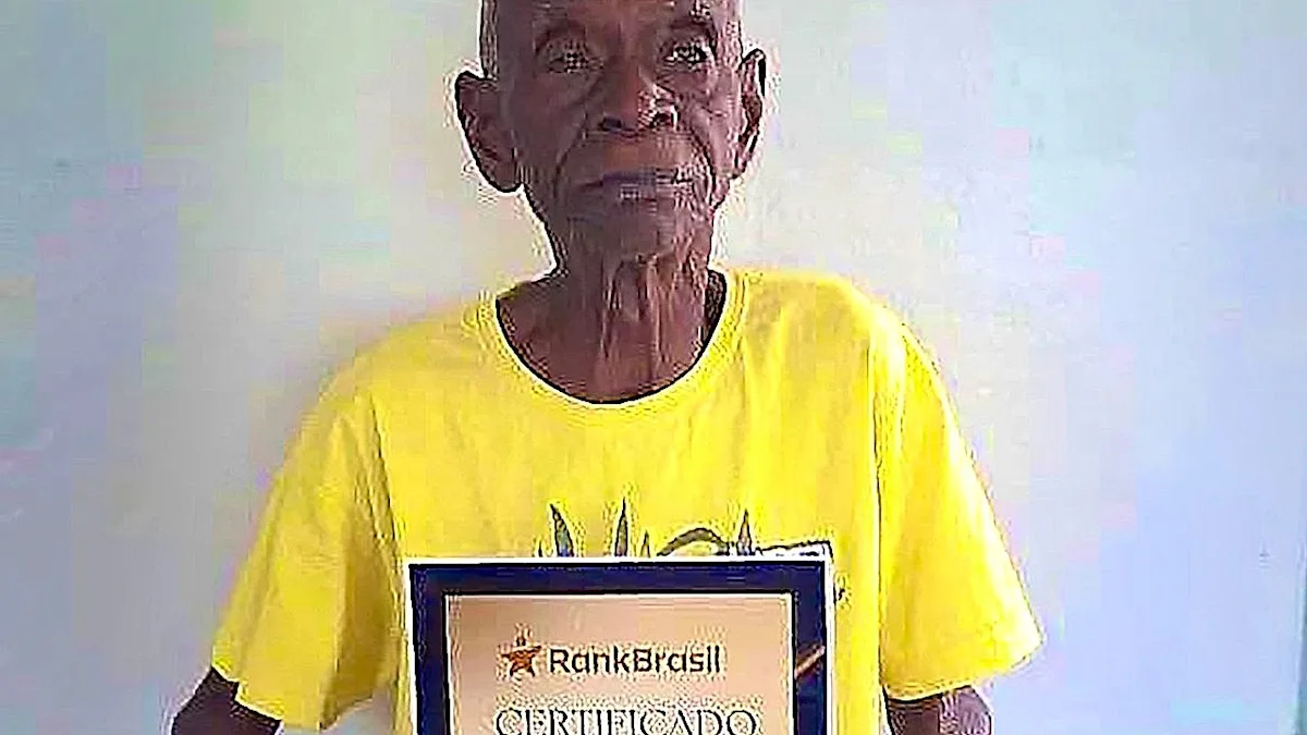 A photo of the Brazilian man, verified as the world's oldest human, with a warm smile and twinkling eyes, surrounded by family and friends, with a colourful background that reflects his remarkable life story and experiences