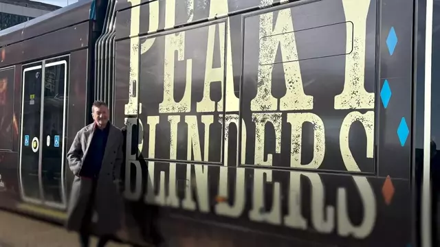 The Peaky Blinders tram, a vibrant and sleek tribute to Steven Knight's writing, featuring the show's logo and colours, a must-see for fans of the show, with its unique design and celebration of the show's success