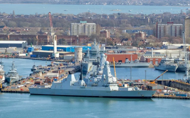 A warship sailing through the Mediterranean Sea, with the UK flag flying high, as the country deploys its military to Cyprus in response to France's aircraft carrier, with the primary keyword being UK military