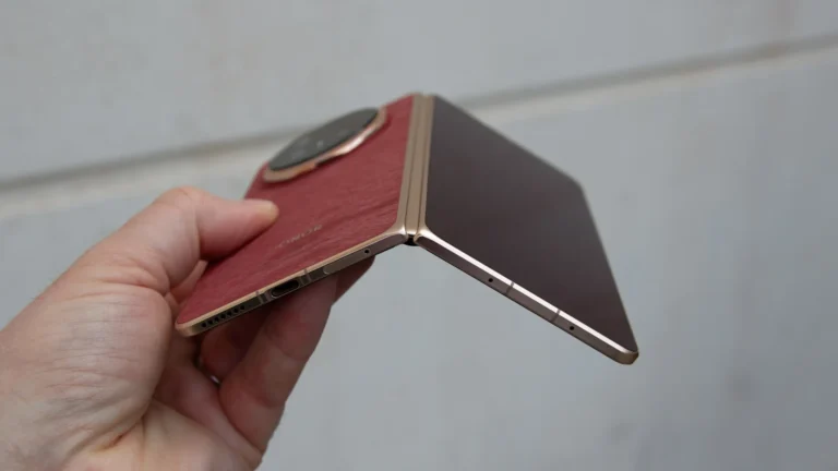 The Honor Magic V6 folding phone in a vibrant red finish, with a slim profile and unique design. The device features a 7.95-inch internal display and 6.52-inch external display, both with a 120Hz refresh rate and peak brightness of 5,000 and 6,000 nits respectively. The Magic V6 is powered by the Snapdragon 8 Elite Gen 5, making it the most powerful folding phone yet, with a huge 6,660mAh battery and 80W wired and 66W wireless charging.