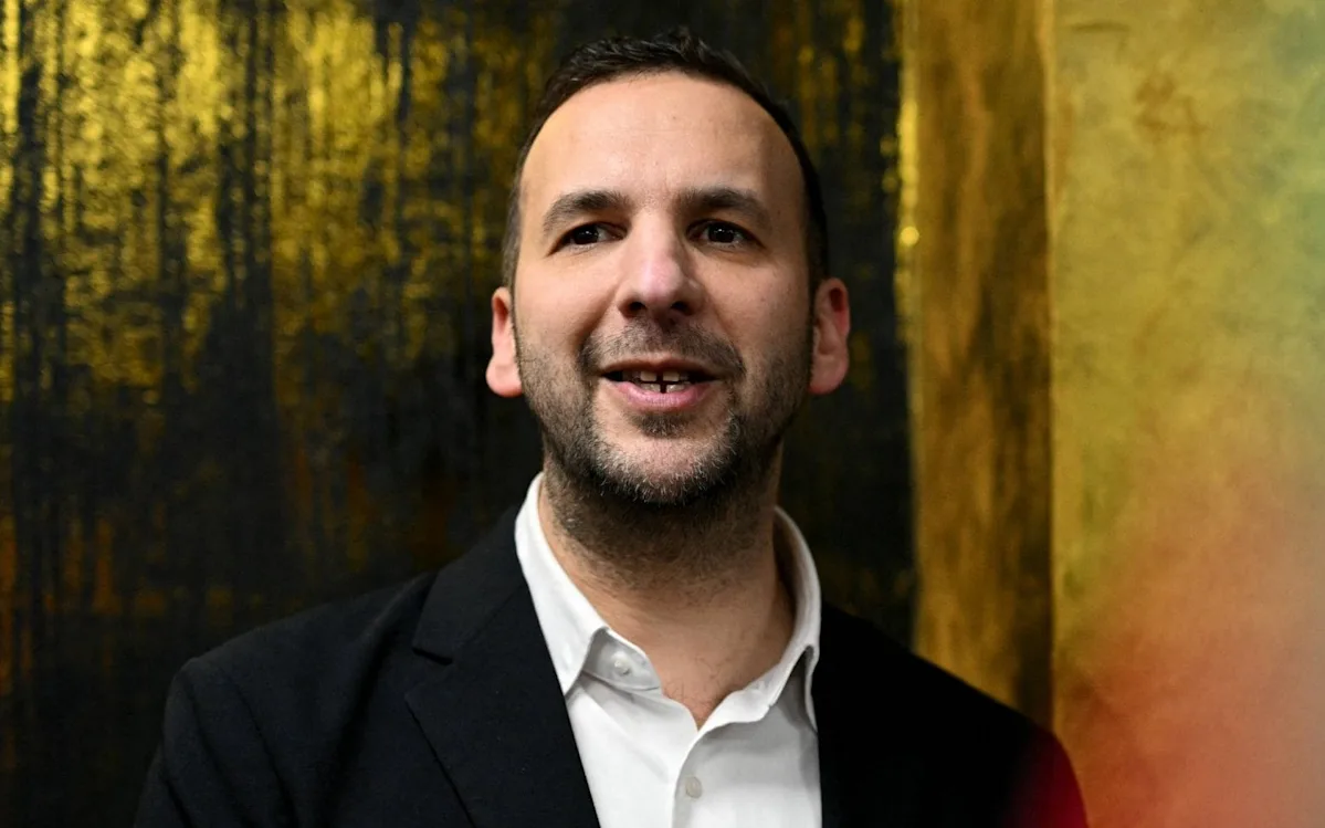A photograph of the vandalised Winston Churchill statue in London, with graffiti and protest signs surrounding the monument, highlighting the controversy and debate surrounding the incident, which has become a focal point for discussions on free speech, historical preservation, and the role of politicians in shaping public discourse