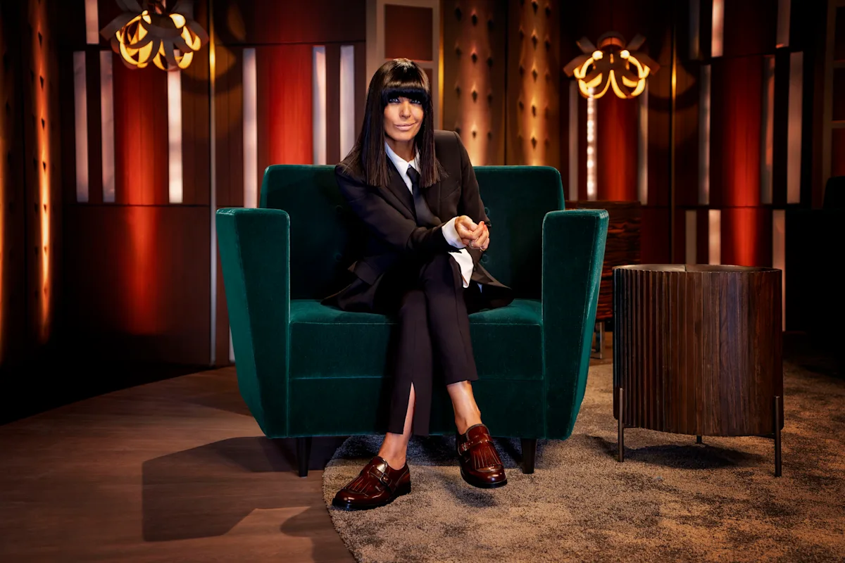 Claudia Winkleman sitting on a couch, smiling and looking confident, with a colourful background, showcasing her new chat show