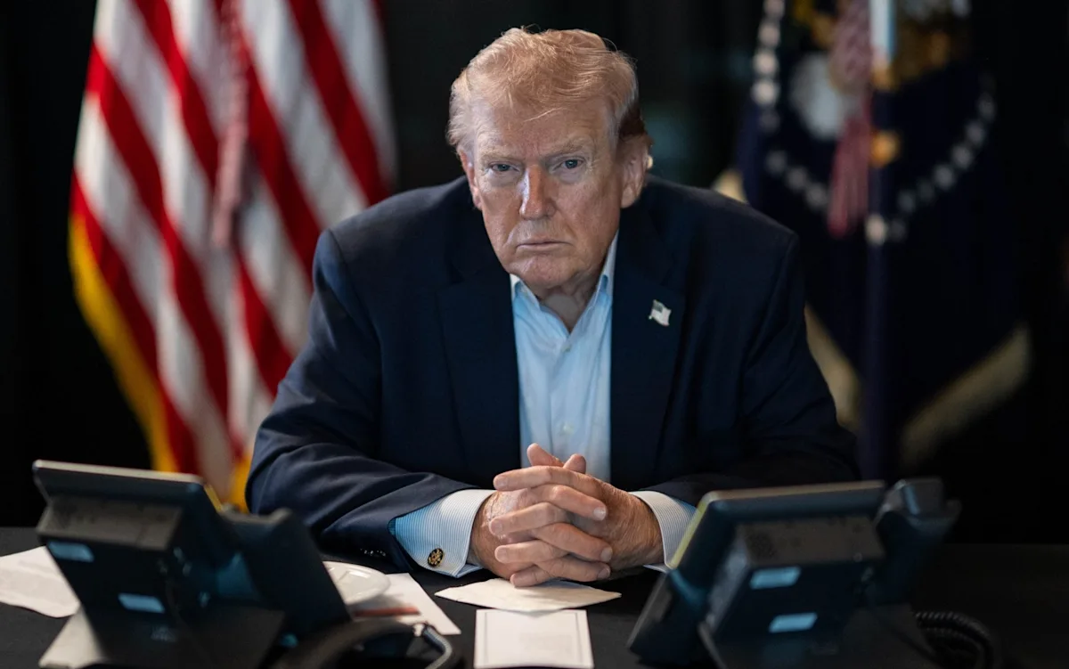 Image of Trump speaking at a press conference, with a stern expression, surrounded by reporters and cameras, highlighting the tension and uncertainty surrounding his demands for unconditional surrender, a key aspect of international relations and diplomacy
