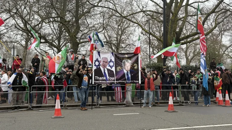 Demonstrators gathered outside the Iranian embassy, holding banners and signs in support of the war efforts, with a focus on peaceful protest and international cooperation, the primary keyword being Iranian embassy demonstration