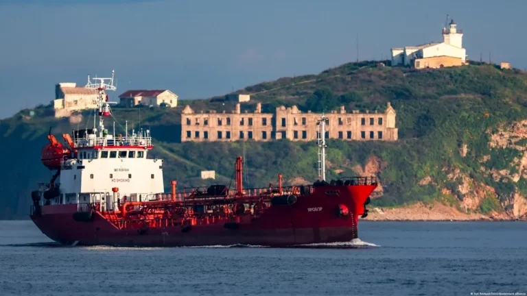 A tanker ship carrying Russian oil stranded at sea, with a US flag in the background, symbolising the temporary permit to sell the oil and alleviate the global energy crisis, as the world struggles to cope with the colour of changing energy dynamics