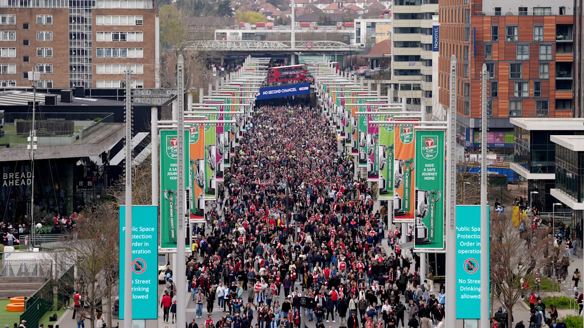 A football stadium with a crowded stand, a police officer in the foreground, and a sign reading 'No Tailgating' - the primary keyword 'tailgating' is a critical aspect of this image