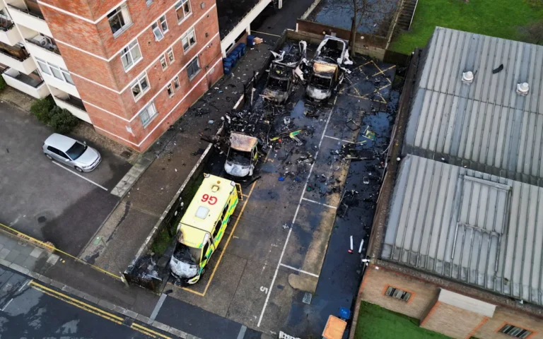 A burning ambulance, a symbol of the rising trend of hate crimes, with a focus on anti-Semitic attacks and the importance of community cohesion and tolerance, as people come together to support the affected emergency responders