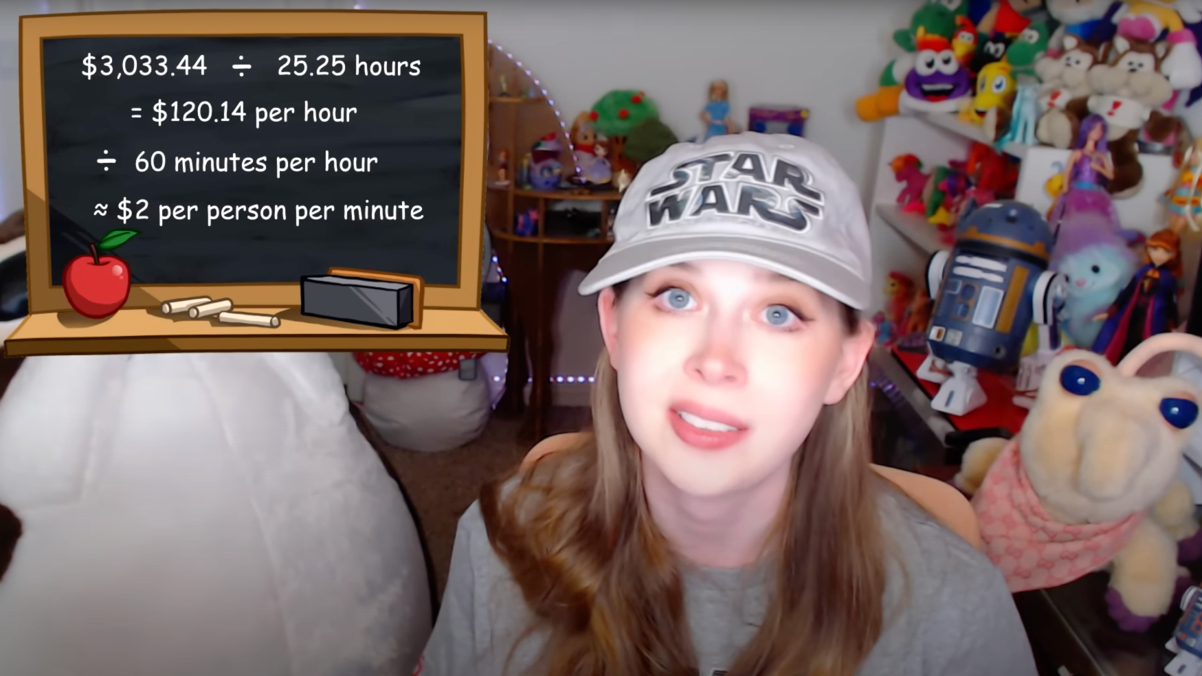 Jenny Nicholson sitting in front of a computer, surrounded by notes and books, with a thoughtful expression, representing her in-depth analysis of fandom culture and viral videos