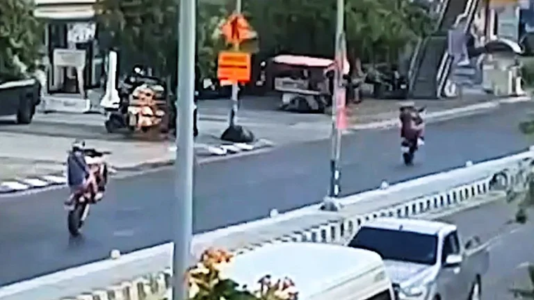 A group of tourists performing a dangerous stunt on a busy road in Thailand, highlighting the need for greater awareness and education about road safety and responsible behaviour