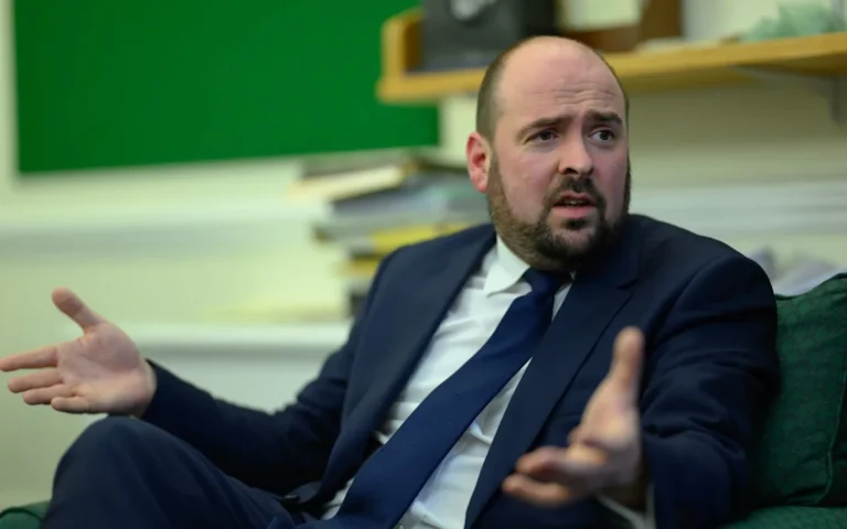 Aerial view of a motorway with a 55mph speed limit sign, highlighting the Green Party's proposal to reduce carbon emissions and promote sustainable transportation