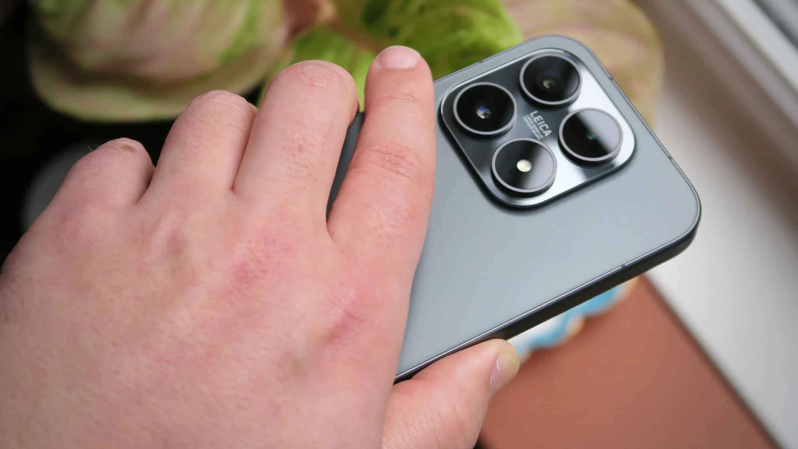 Xiaomi phone and MacBook on a desk, with a file being transferred between the two devices, showcasing Xiaomi's interconnectivity feature in action, with a UK cityscape in the background