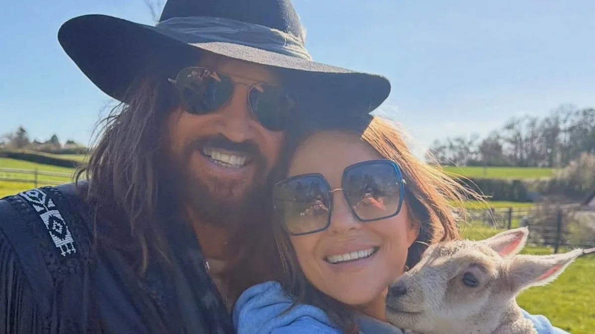 Elizabeth Hurley and Billy Ray Cyrus pose together, smiling and happy, on their anniversary celebration, surrounded by love and commitment, with a beautiful backdrop, celebrating their special day, with a romantic atmosphere, and a deep love for each other