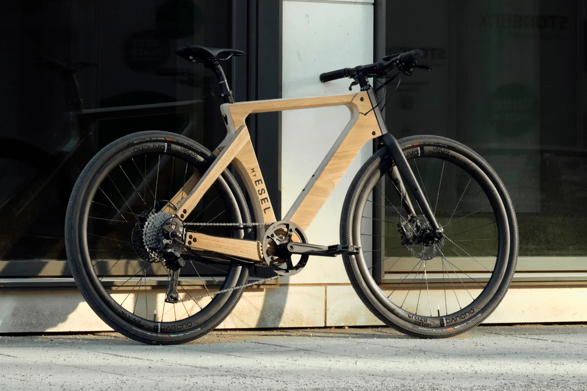 Esel's eUrban electric bike with ash-wood construction and carbon wheels, featuring a rear wheel hub drive and 350 Wh battery, delivering 42 Nm of torque and 80 km of range, perfect for city commuting in the UK