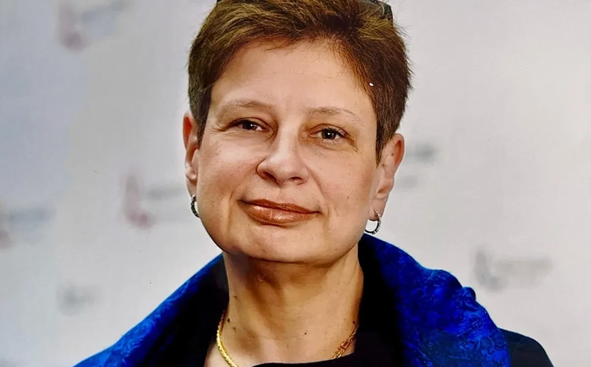 A photo of a person holding a sign that reads 'Resistance Against Tyranny', with a blurred background of people protesting in the distance, symbolising the ongoing struggle for freedom and human rights, with the primary keyword 'resistance' naturally included