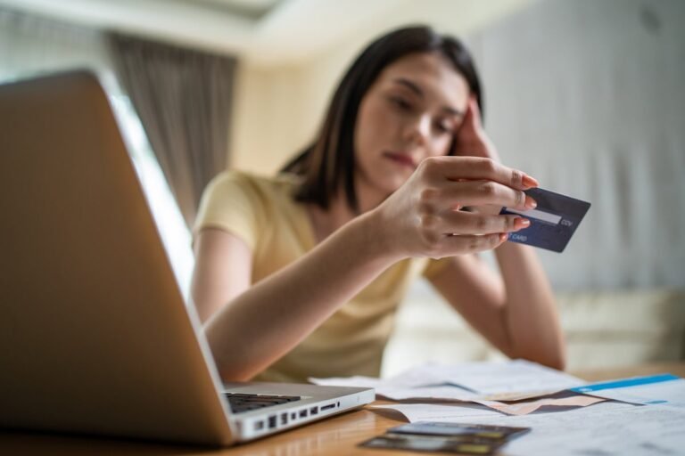 UK adult looking at empty wallet with concern