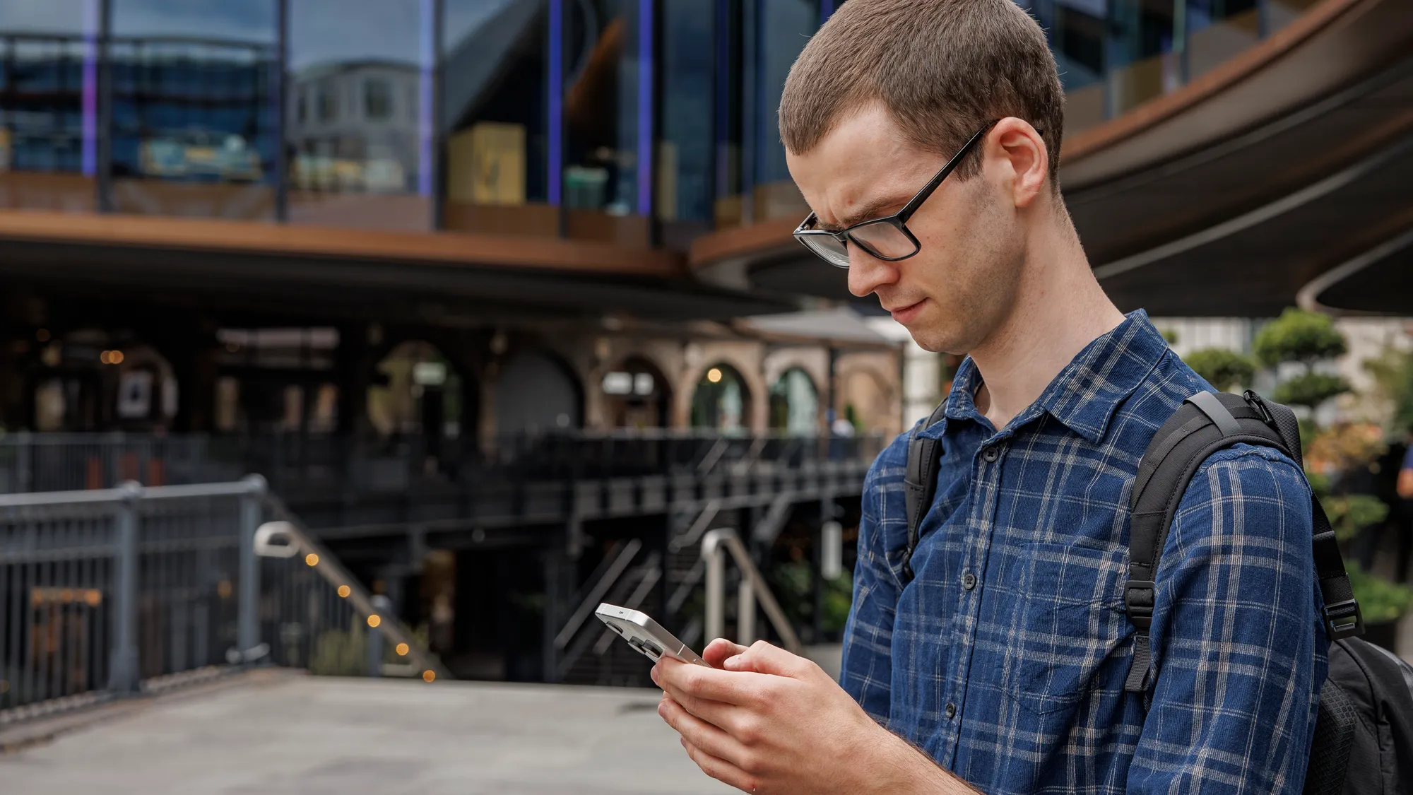 A person holding a smartphone with a green leaf in the background, symbolizing sustainability and eco-friendliness, with a focus on reducing e-waste and promoting a circular economy
