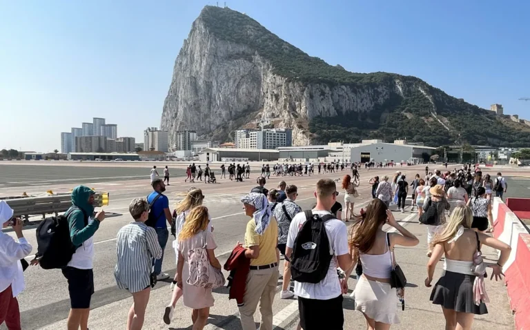 A descriptive image of the Gibraltar border with a fingerprint scanner in the foreground, highlighting the EU's fingerprint entry scheme and its implications for Brexit and UK-EU relations