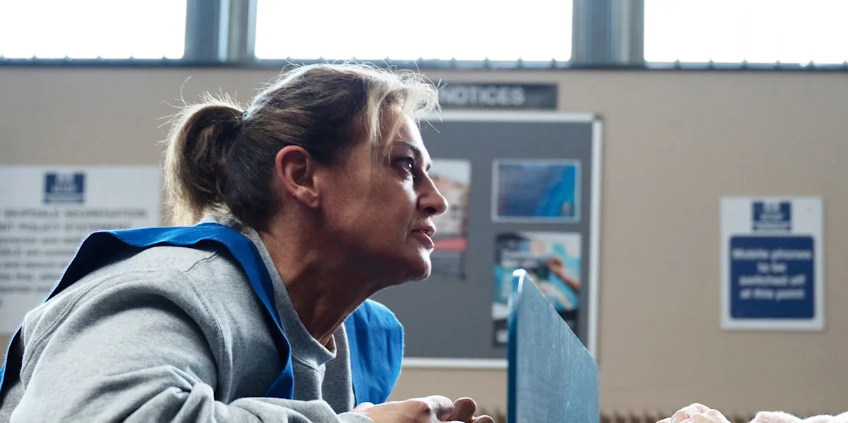 Emmerdale's Moira and Kim standing together, looking concerned, with a village landscape in the background, highlighting the show's dramatic and suspenseful nature, with a mix of colour and darkness