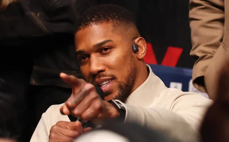 Tyson Fury and Anthony Joshua face off in the ring, surrounded by a sea of colour and excitement, as they prepare for their highly anticipated boxing match, with the heavyweight division title on the line