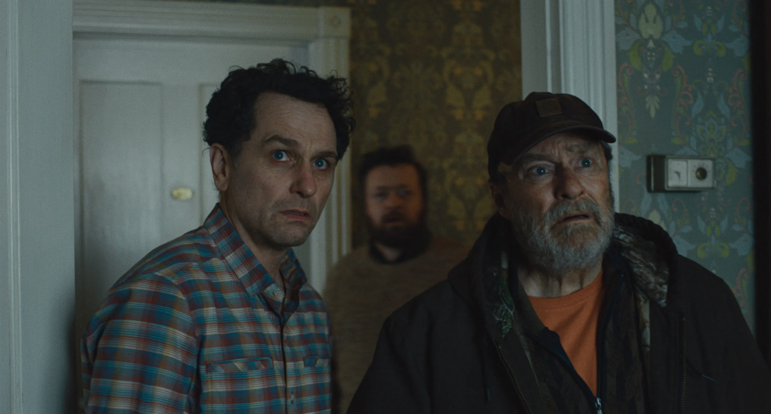 A eerie and atmospheric image of the island of Widow's Bay, with a full moon hanging low in the sky, casting an ominous glow over the landscape, including the old inn and the local residents, capturing the show's primary keyword, Widow's Bay