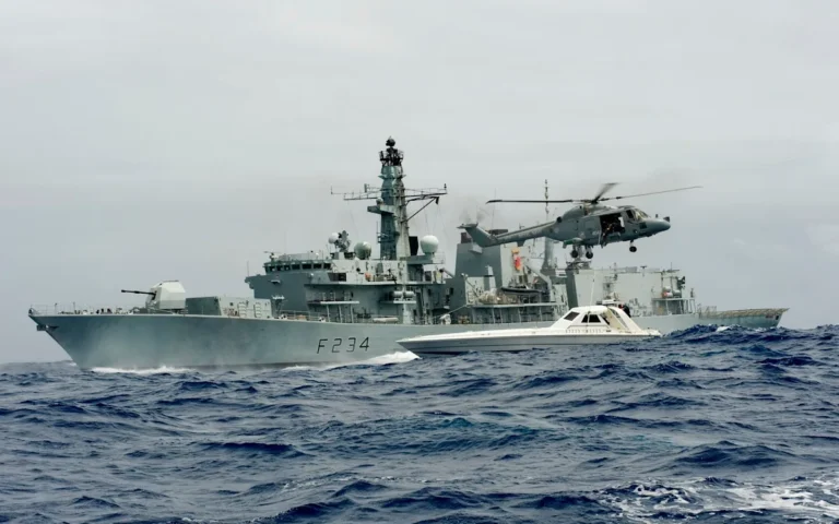 A Royal Navy frigate at sea, with the UK flag flying high, symbolising the nation's maritime defence capabilities and the importance of a strong frigate fleet in maintaining security and defending against emerging threats