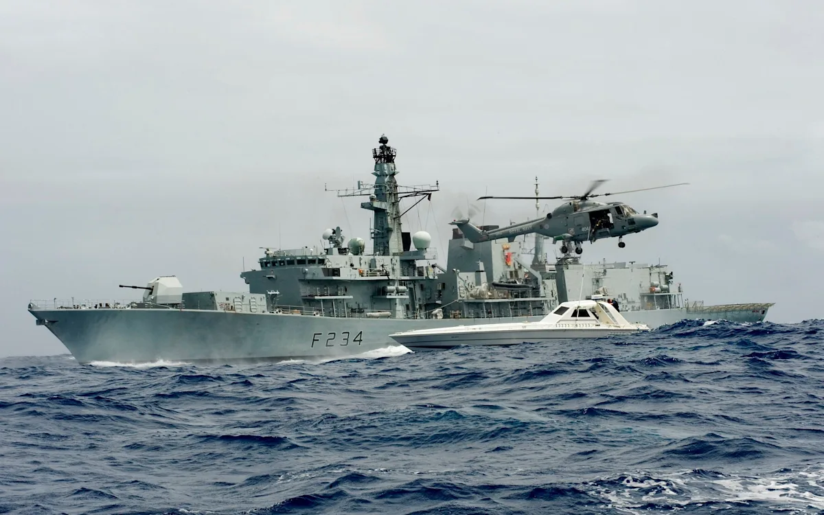 A Royal Navy frigate at sea, with the UK flag flying high, symbolising the nation's maritime defence capabilities and the importance of a strong frigate fleet in maintaining security and defending against emerging threats