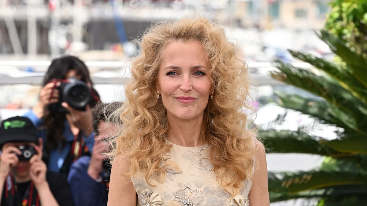 Gillian Anderson walks the red carpet at Cannes Film Festival, showcasing her stunning 80s-style curls and captivating smile, in a beautiful colour palette that perfectly complements her hair, with a confident behaviour that inspires many