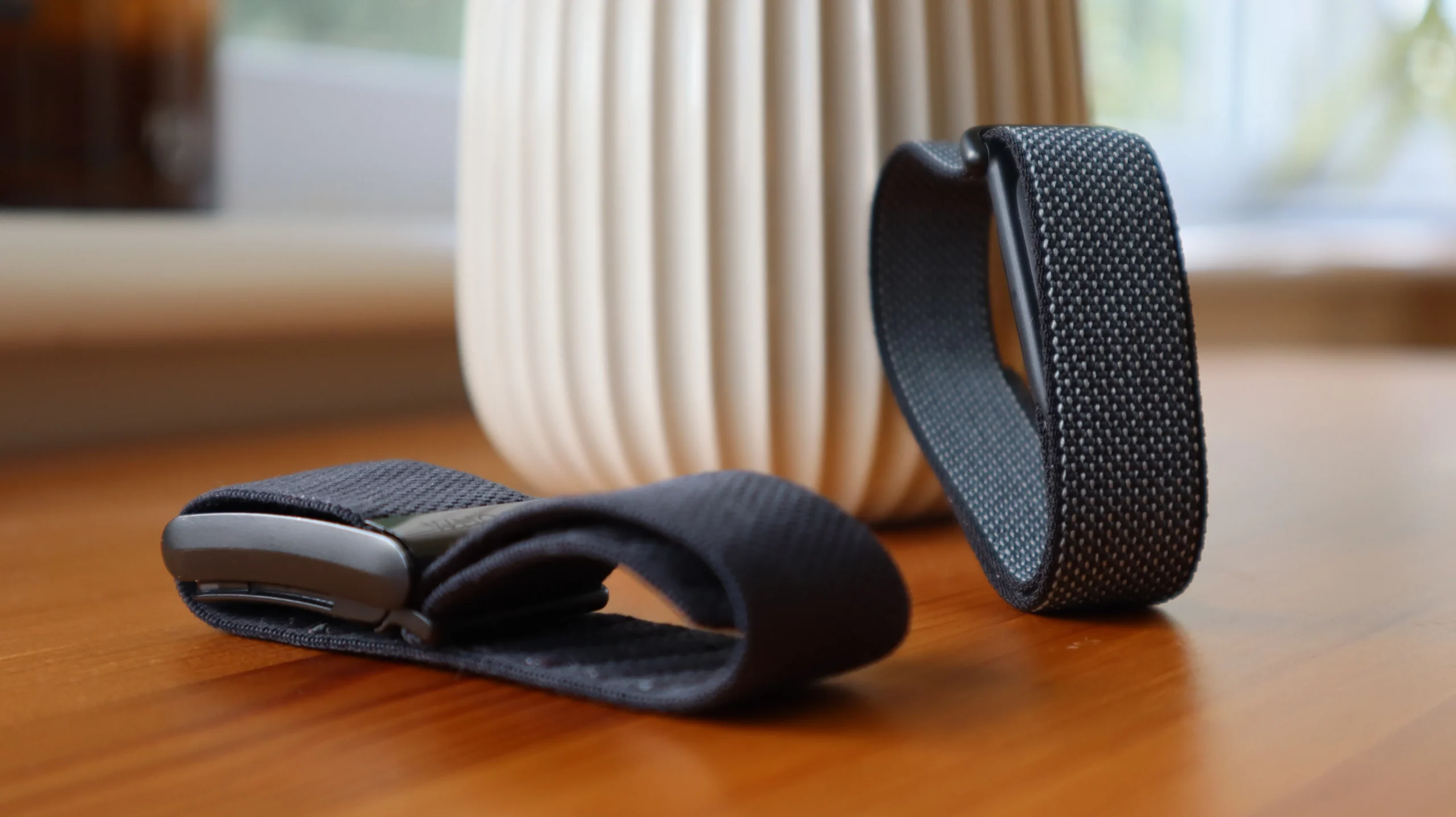 A person wearing a Fitbit Air and a Whoop Strap, with a cityscape in the background, highlighting the UK's fitness tracking scene and the primary keyword 'screenless fitness trackers'