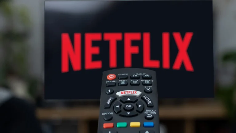 A person holding a remote control, with a TV screen displaying a Netflix menu in the background, with a caption Discover hidden gems on Netflix UK