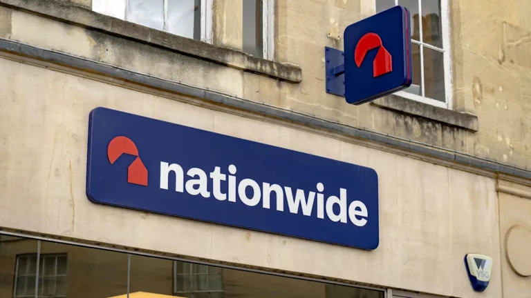 Nationwide £100 bonus for customers, a man holding a tablet with a surprised expression, with a background colour of blue, representing trust and loyalty, the primary keyword is Nationwide £100 bonus