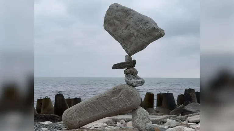 A man carefully balances rocks on top of each other, creating a stunning gravity-defying structure, with the primary keyword rock balancing, in a beautiful outdoor setting with a serene colour palette