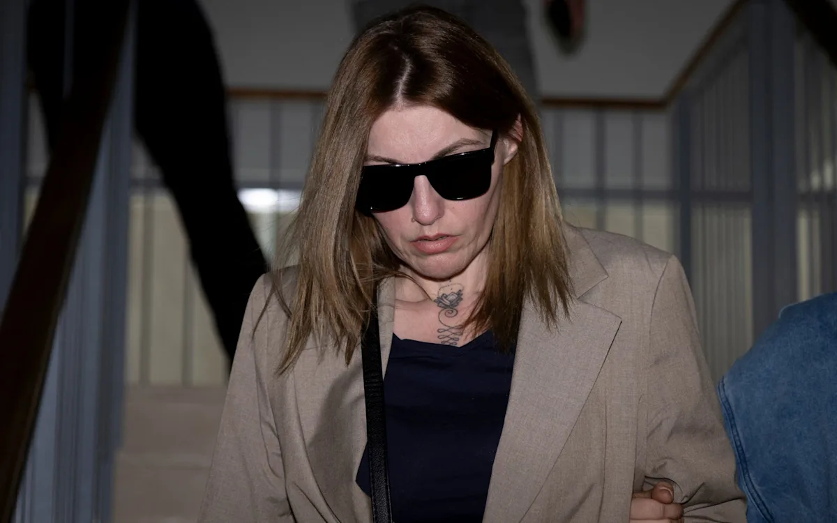 A person in handcuffs, representing the banker who was jailed for pimping his girlfriend to hundreds of men, with a focus on human trafficking and exploitation
