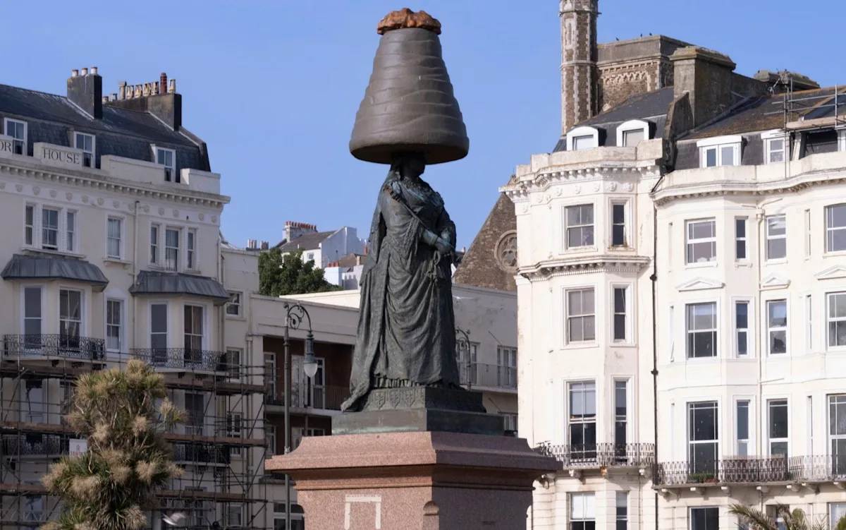 A photo of Queen Victoria with a Walnut Whip on her head, symbolising the mischievous prank that has sparked outrage and amusement, featuring the classic British dessert in a surprising and unexpected way