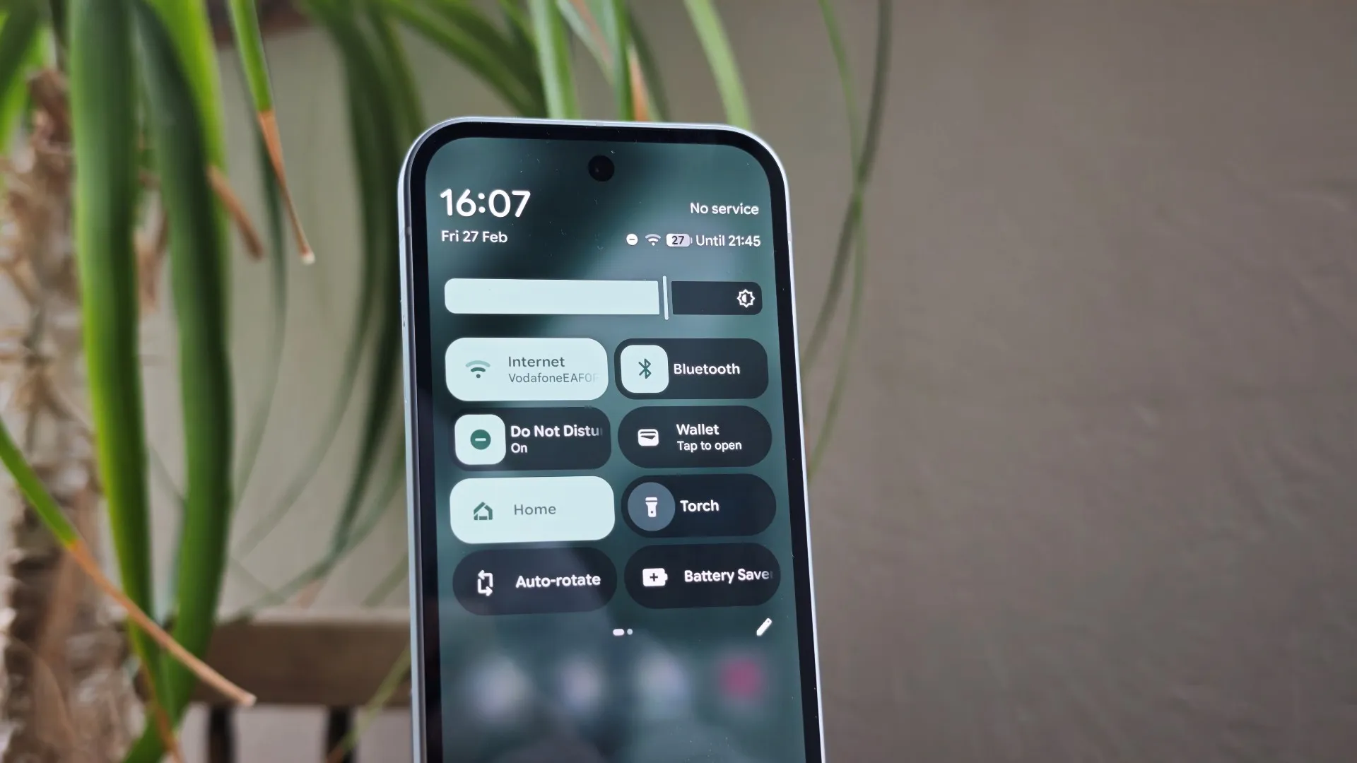 A person holding a phone with a photo of a cityscape on the screen, with a subtle AI-generated effect. The photo is clear and of high quality, with the AI features enhancing the overall image. The UK cityscape is a great example of how AI can improve our daily lives.