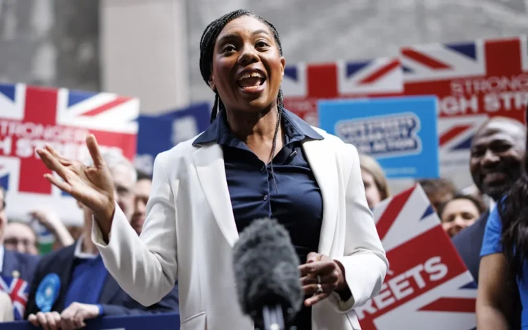 Kate Badenoch speaking at a Conservative Party event, surrounded by professionals from diverse backgrounds, including teachers and builders, highlighting the party's commitment to diversity and inclusion
