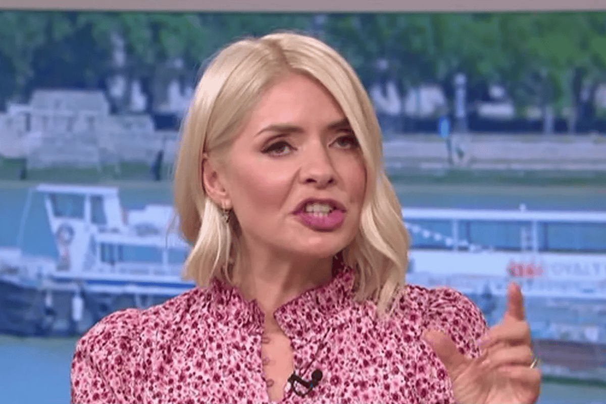 Holly Willoughby poses for a photo, looking elegant in a red dress, with a fearful expression on her face, as she is ruled out of hosting Strictly Come Dancing due to her behaviour, the BBC is now looking for a new host to front the popular dance competition