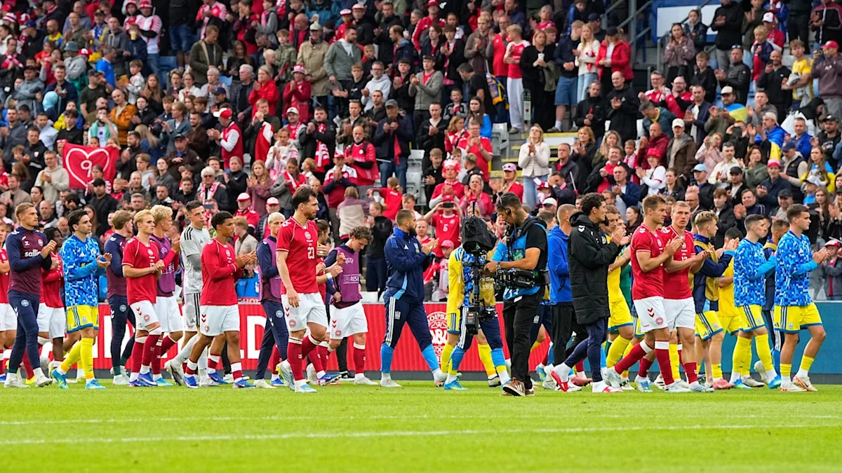 Christian Eriksen collapses on the pitch during a Denmark game, surrounded by concerned teammates and opponents, highlighting the importance of player safety and health in football, with the football community coming together to offer support