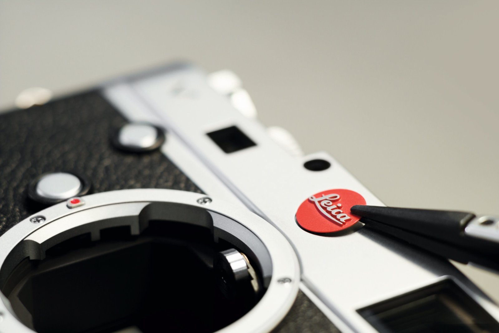 A close-up of a Leica camera, with a blurred background of a cityscape, showcasing the camera's exceptional quality and attention to detail, a true luxury brand in the photography industry