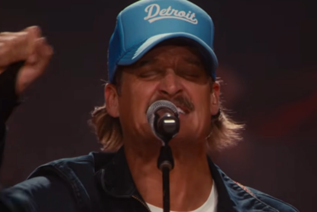 A crowd of people watching the Super Bowl halftime show on a large screen, with a mix of excitement and anticipation on their faces, as they enjoy the colour and energy of the event, with the primary keyword being Super Bowl halftime show