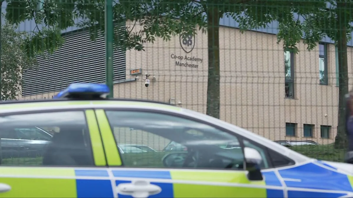 A photo of a school in Manchester, with a police car outside, following a stabbing incident that left two pupils and a teacher injured, highlighting the need for increased pupil safety and security measures