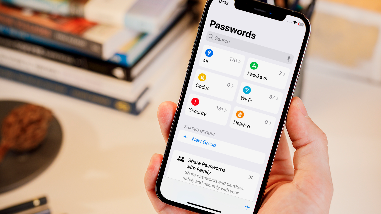 A person holding an iPhone with a password management screen, with a UK flag in the background, highlighting the importance of online security and password management in the UK