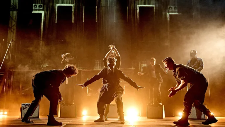 A dramatic image of the Barbican theatre in London, with a glimpse of the Radiohead's Hamlet production in the background, showcasing the fusion of music and theatre