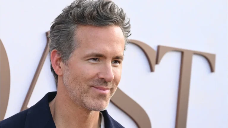 Ryan Reynolds smiling, with a subtle hint of his scars, symbolising his strength and resilience, a true Hollywood star who has been through a life-altering accident and has come out stronger, with every bone on his left side broken, but his spirit unbroken, a testament to his perseverance and determination