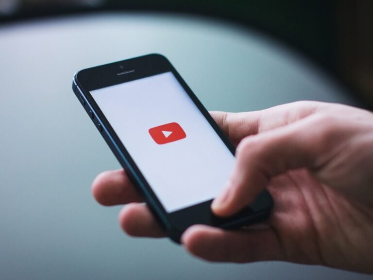 A person listening to music on their phone with the screen locked, representing the background playback feature that is now exclusive to YouTube Premium subscribers, which offers a range of benefits including ad-free videos and offline playback.