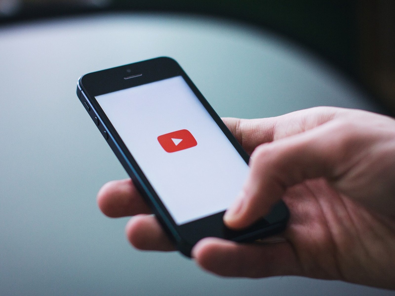 A person listening to music on their phone with the screen locked, representing the background playback feature that is now exclusive to YouTube Premium subscribers, which offers a range of benefits including ad-free videos and offline playback.