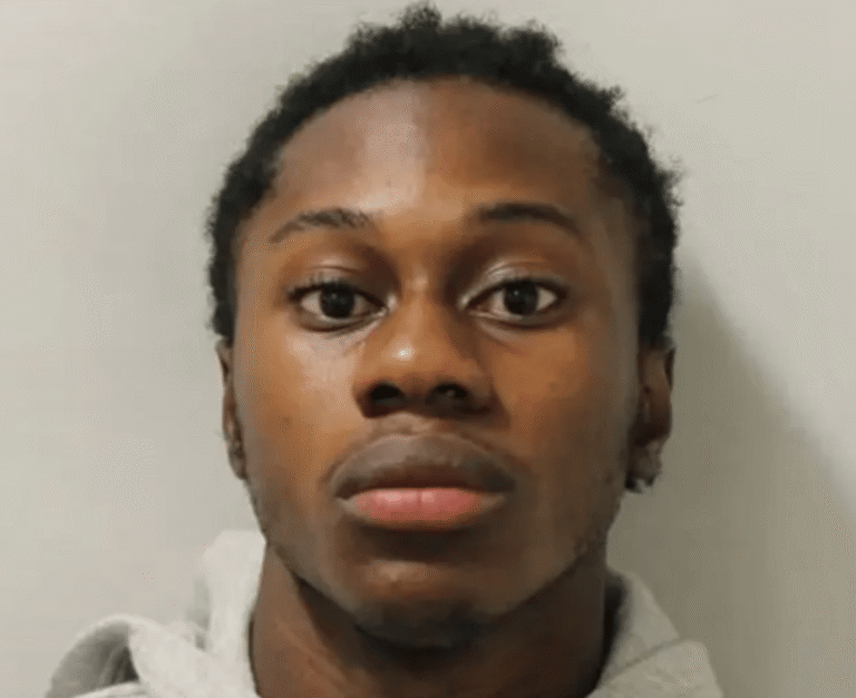 A photo of a prisoner in a cell, with a police officer standing guard in the background, the primary keyword 'prisoner escape' is illustrated by the prisoner attempting to climb over the wall