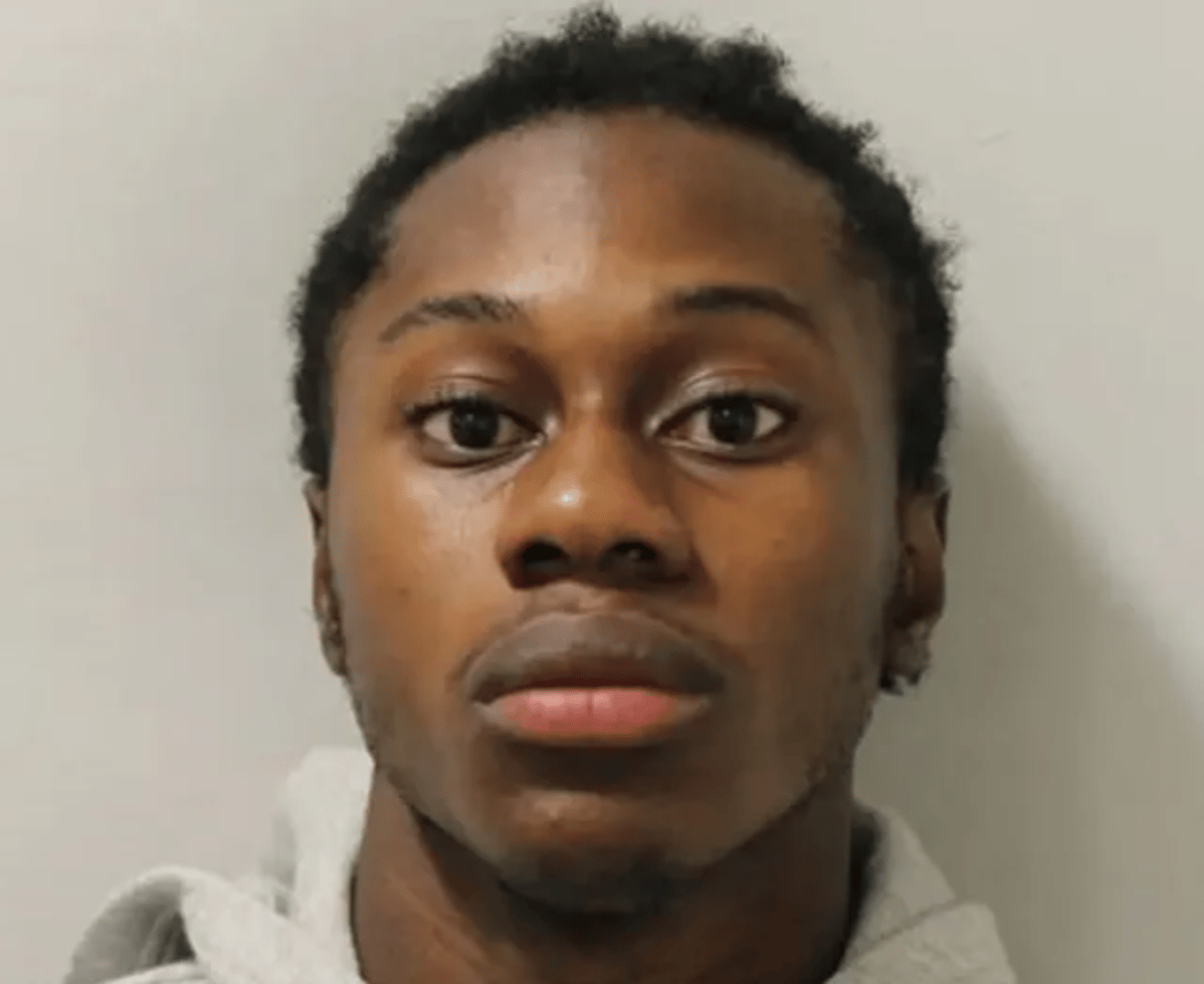 A photo of a prisoner in a cell, with a police officer standing guard in the background, the primary keyword 'prisoner escape' is illustrated by the prisoner attempting to climb over the wall