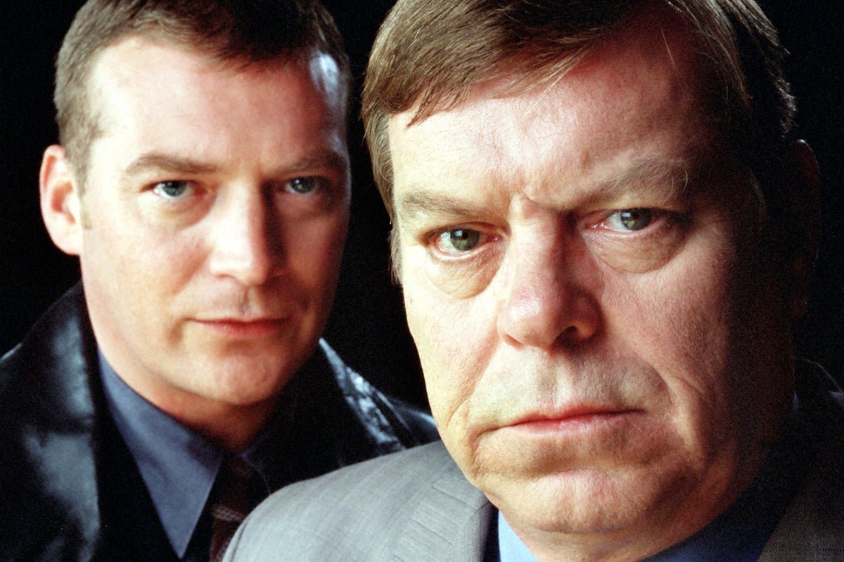 Detective Superintendent Andy Dalziel and Detective Inspector Peter Pascoe investigating a crime scene, with a cityscape in the background, showcasing the show's unique blend of humour and suspense, with a gender flipped twist, in the rebooted series